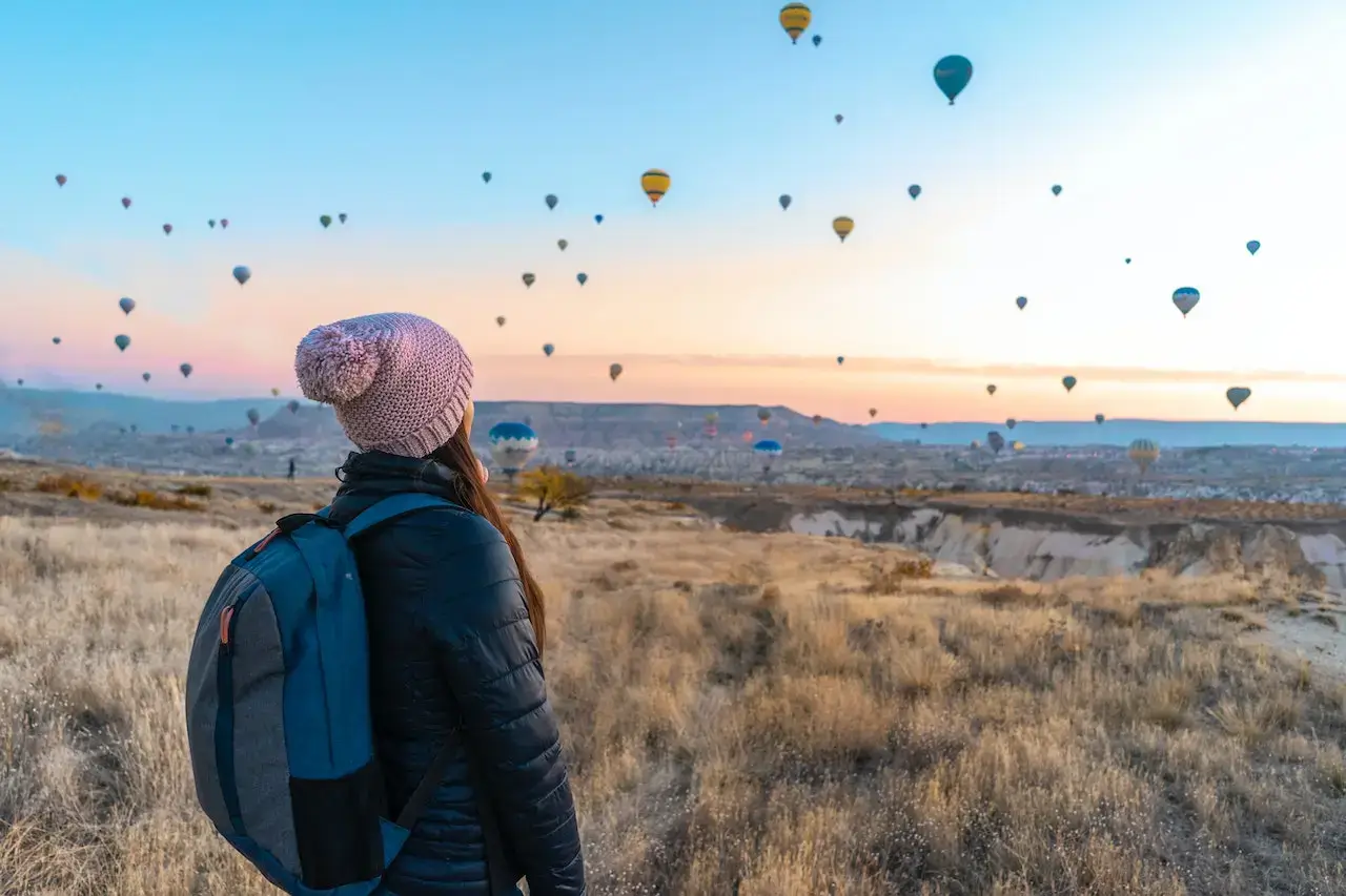 chica contemplando el horizonte, lleno de globos