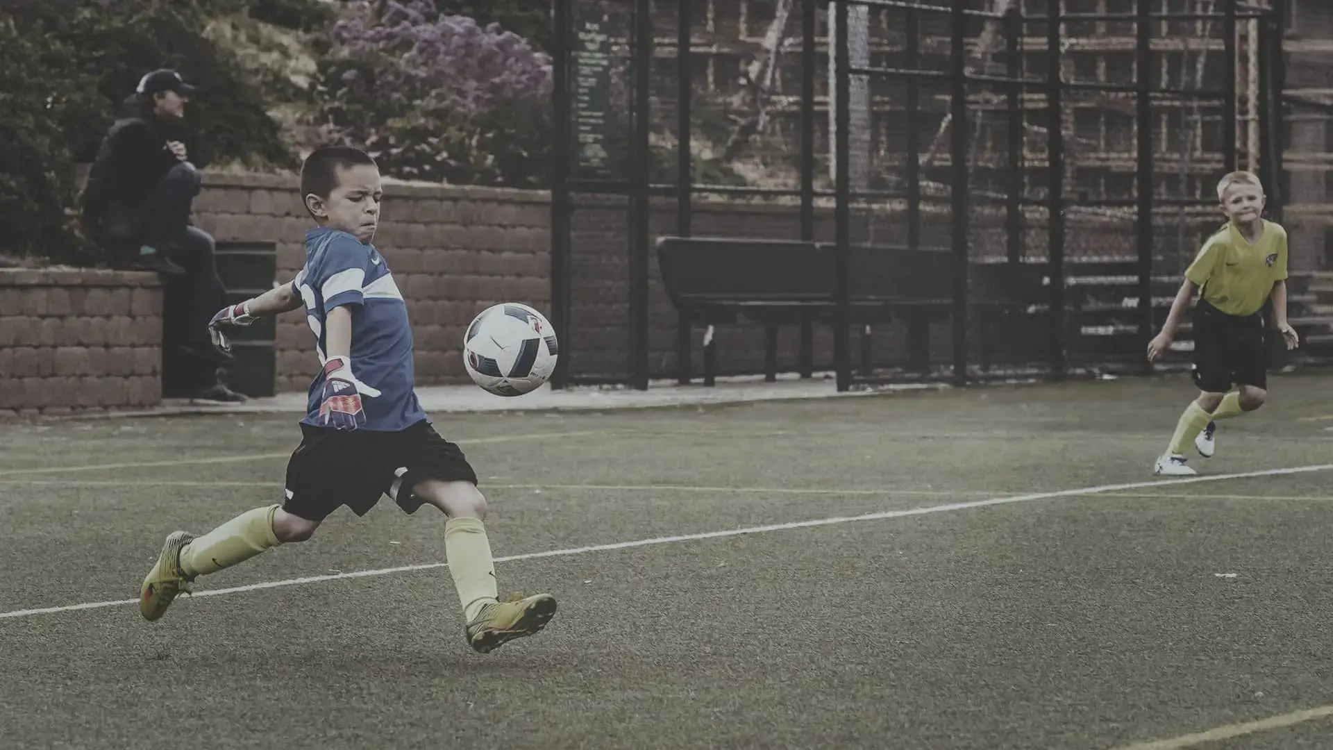 portero menor chutando pelota durante un partido de fútbol